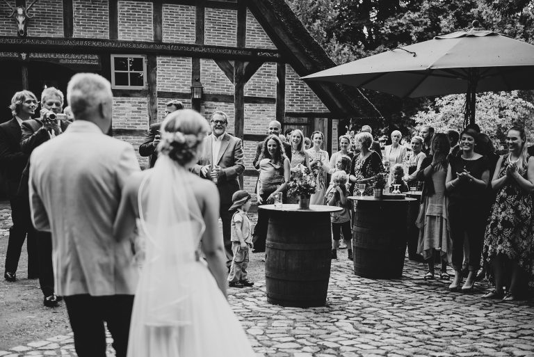 Hochzeitsfotografie-Frau-Siemers-Hof Weihe-Braut trifft am Hof ein und wird von den Gästen empfangen