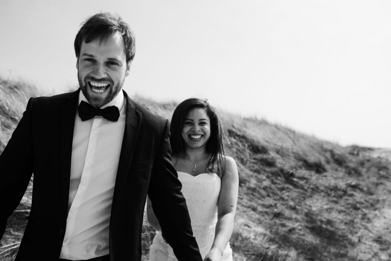 Sankt-Peter-Ording- Hochzeitsbilder- Mit Blick auf die Dünen. Brautpaar lacht in die Kamera
