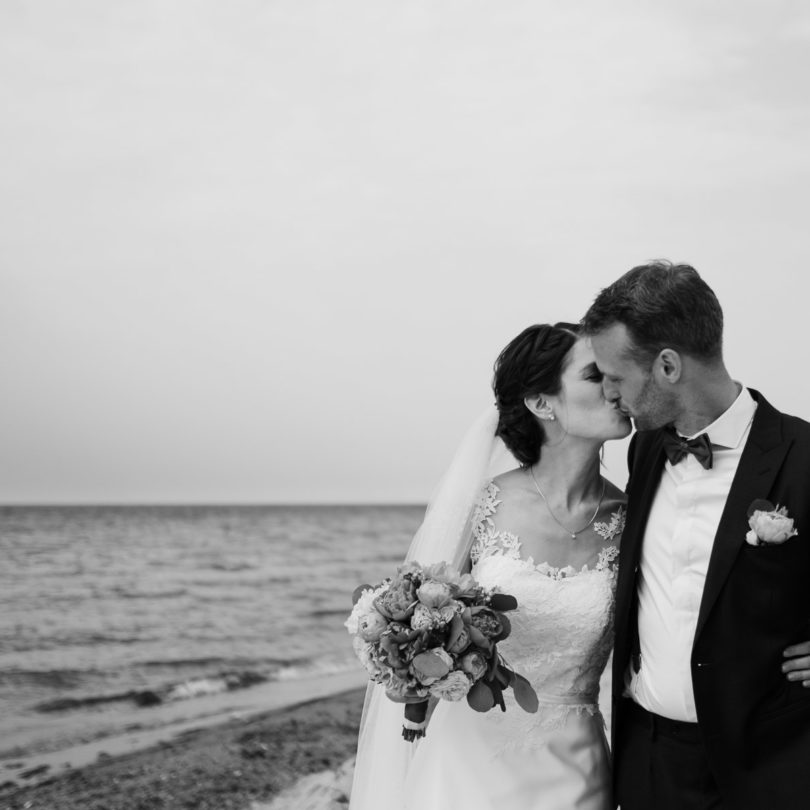 Schlossgut-Groß-Schwansee- Hochzeitsfotografie- Hochzeitsbilder na der Ostsee- Hochzeitspaar geht Arm in Arm die See entlang