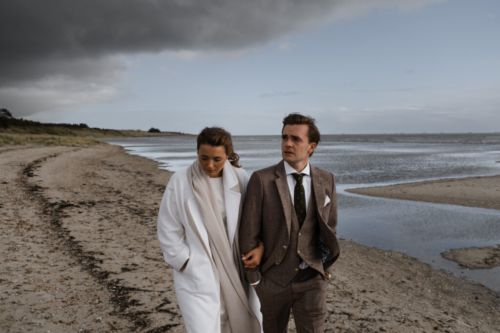 Hochzeitsfotograf Föhr- standesamtliche Trauung- Weingut Waalem- Hochzeitsportrait am Meer- Paar spaziert am Meer