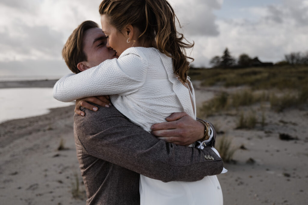 Hochzeitsfotograf Föhr- standesamtliche Trauung- Weingut Waalem- Hochzeitsportrait am Meer- Paar umarmt sich