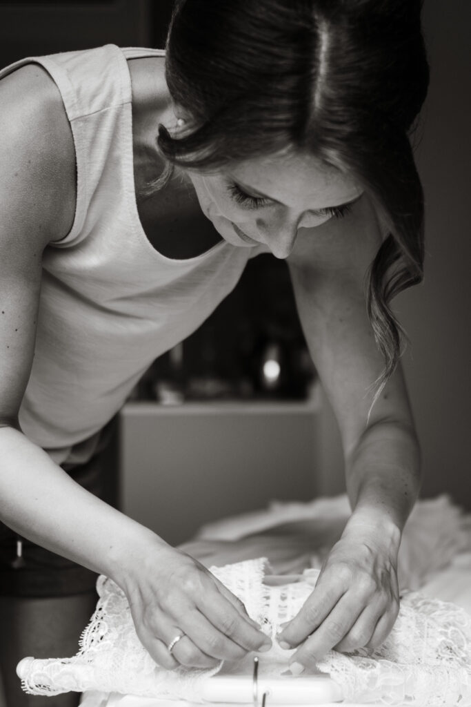 Hochzeitsfotografie Kieler Kaufmann-Getting Ready- Braut öffnet Knöpfe des Hochzeitskleides