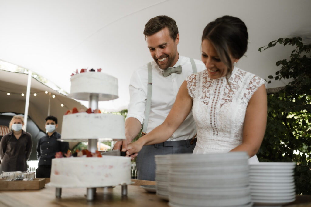 Hochzeitsfotografie Seehotel-Töpferhaus-Freie Trauung- Hochzeitspaar schneidet die Hochzeitstorte an.