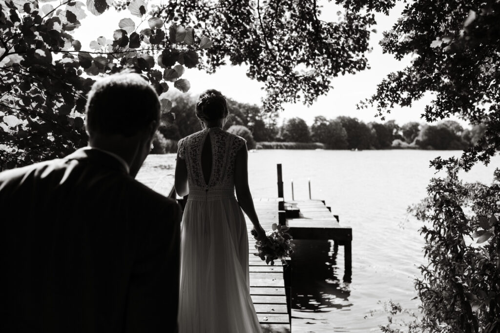 Hochzeitsfotografie Seehotel-Töpferhaus-Portrait- Hochzeitspaar-geht gemeinsam auf den Steg