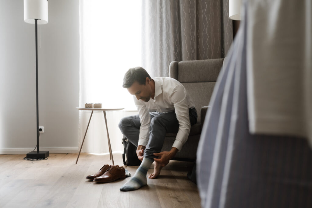 Hochzeitsfotografie Kieler Kaufmann-Getting Ready- Bräutigam bindet sich die Schuhe zu