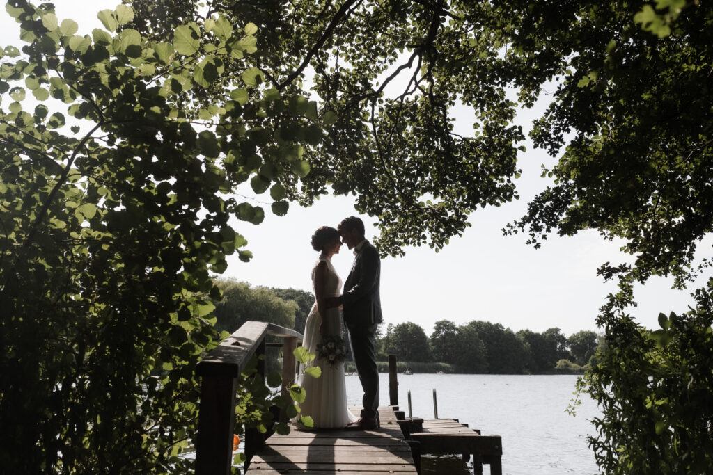 Hochzeitsfotografie Seehotel-Töpferhaus-Portrait- Hochzeitspaar-Gegenlichtaufnahme auf dem Steg